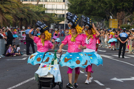 SANTA CRUZ DE TENERIFE, SPAIN - FEBRUARY 13, 2024: The Coso parade, Cavalcada - along the Avenida de Anaga, official end of Carnival. Amazing warm evening, joyful people in carnival costumes have fun.のeditorial素材