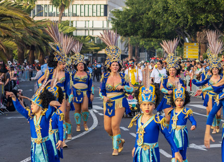 SANTA CRUZ DE TENERIFE, SPAIN - FEBRUARY 13, 2024: The Coso parade, Cavalcada - along the Avenida de Anaga, official end of Carnival. Amazing warm evening, joyful people in carnival costumes have fun.のeditorial素材