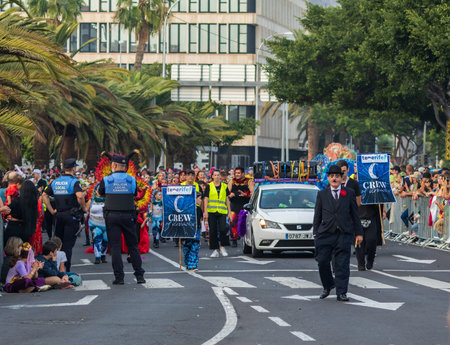 SANTA CRUZ DE TENERIFE, SPAIN - FEBRUARY 13, 2024: The Coso parade, Cavalcada - along the Avenida de Anaga, official end of Carnival. Amazing warm evening, joyful people in carnival costumes have fun.のeditorial素材