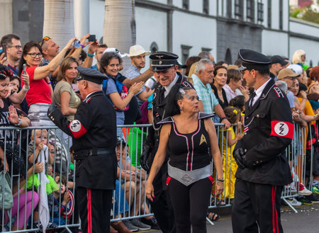 SANTA CRUZ DE TENERIFE, SPAIN - FEBRUARY 13, 2024: The Coso parade, Cavalcada - along the Avenida de Anaga, official end of Carnival. Amazing warm evening, joyful people in carnival costumes have fun.のeditorial素材