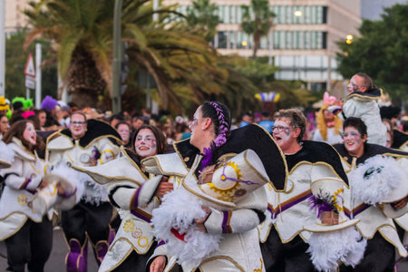 SANTA CRUZ DE TENERIFE, SPAIN - FEBRUARY 13, 2024: The Coso parade, Cavalcada - along the Avenida de Anaga, official end of Carnival. Amazing warm evening, joyful people in carnival costumes have fun.のeditorial素材