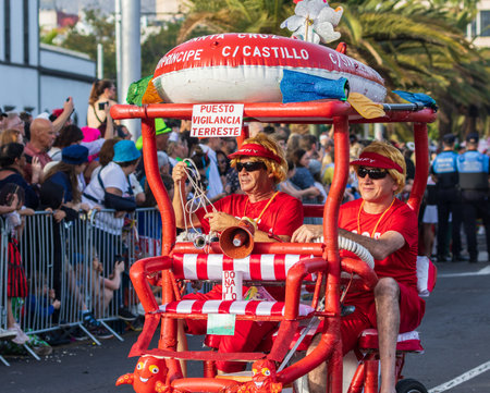 SANTA CRUZ DE TENERIFE, SPAIN - FEBRUARY 13, 2024: The Coso parade, Cavalcada - along the Avenida de Anaga, official end of Carnival. Amazing warm evening, joyful people in carnival costumes have fun.のeditorial素材