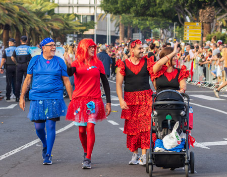 SANTA CRUZ DE TENERIFE, SPAIN - FEBRUARY 13, 2024: The Coso parade, Cavalcada - along the Avenida de Anaga, official end of Carnival. Amazing warm evening, joyful people in carnival costumes have fun.のeditorial素材