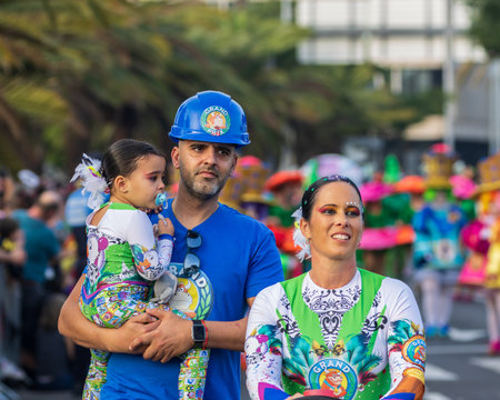 SANTA CRUZ DE TENERIFE, SPAIN - FEBRUARY 13, 2024: The Coso parade, Cavalcada - along the Avenida de Anaga, official end of Carnival. Amazing warm evening, joyful people in carnival costumes have fun.のeditorial素材