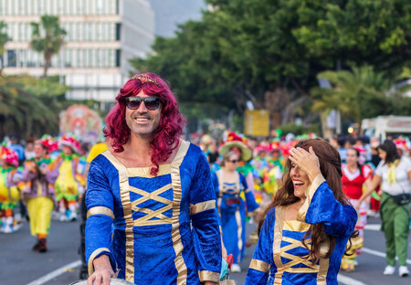 SANTA CRUZ DE TENERIFE, SPAIN - FEBRUARY 13, 2024: The Coso parade, Cavalcada - along the Avenida de Anaga, official end of Carnival. Amazing warm evening, joyful people in carnival costumes have fun.のeditorial素材