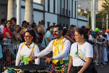 SANTA CRUZ DE TENERIFE, SPAIN - FEBRUARY 13, 2024: The Coso parade, Cavalcada - along the Avenida de Anaga, official end of Carnival. Amazing warm evening, joyful people in carnival costumes have fun.のeditorial素材