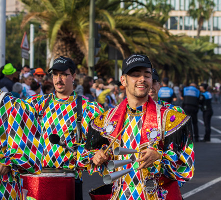 SANTA CRUZ DE TENERIFE, SPAIN - FEBRUARY 13, 2024: The Coso parade, Cavalcada - along the Avenida de Anaga, official end of Carnival. Amazing warm evening, joyful people in carnival costumes have fun.のeditorial素材