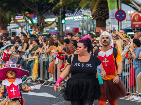 SANTA CRUZ DE TENERIFE, SPAIN - FEBRUARY 13, 2024: The Coso parade, Cavalcada - along the Avenida de Anaga, official end of Carnival. Amazing warm evening, joyful people in carnival costumes have fun.のeditorial素材