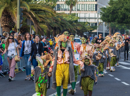 SANTA CRUZ DE TENERIFE, SPAIN - FEBRUARY 13, 2024: The Coso parade, Cavalcada - along the Avenida de Anaga, official end of Carnival. Amazing warm evening, joyful people in carnival costumes have fun.のeditorial素材