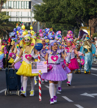 SANTA CRUZ DE TENERIFE, SPAIN - FEBRUARY 13, 2024: The Coso parade, Cavalcada - along the Avenida de Anaga, official end of Carnival. Amazing warm evening, joyful people in carnival costumes have fun.のeditorial素材