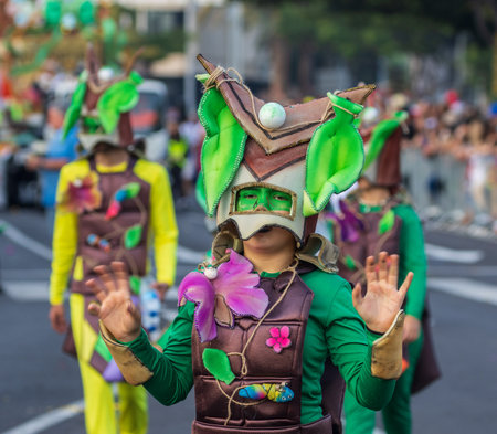 SANTA CRUZ DE TENERIFE, SPAIN - FEBRUARY 13, 2024: The Coso parade, Cavalcada - along the Avenida de Anaga, official end of Carnival. Amazing warm evening, joyful people in carnival costumes have fun.のeditorial素材