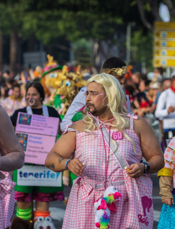 SANTA CRUZ DE TENERIFE, SPAIN - FEBRUARY 13, 2024: The Coso parade, Cavalcada - along the Avenida de Anaga, official end of Carnival. Amazing warm evening, joyful people in carnival costumes have fun.のeditorial素材