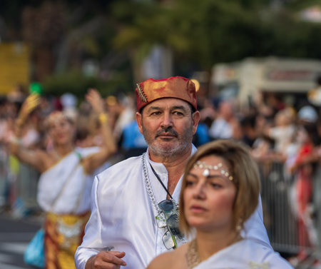 SANTA CRUZ DE TENERIFE, SPAIN - FEBRUARY 13, 2024: The Coso parade, Cavalcada - along the Avenida de Anaga, official end of Carnival. Amazing warm evening, joyful people in carnival costumes have fun.のeditorial素材