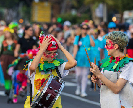 SANTA CRUZ DE TENERIFE, SPAIN - FEBRUARY 13, 2024: The Coso parade, Cavalcada - along the Avenida de Anaga, official end of Carnival. Amazing warm evening, joyful people in carnival costumes have fun.のeditorial素材
