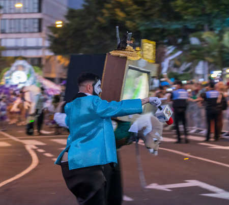 SANTA CRUZ DE TENERIFE, SPAIN - FEBRUARY 13, 2024: The Coso parade, Cavalcada - along the Avenida de Anaga, official end of Carnival. Amazing warm evening, joyful people in carnival costumes have fun.のeditorial素材