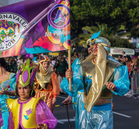 SANTA CRUZ DE TENERIFE, SPAIN - FEBRUARY 13, 2024: The Coso parade, Cavalcada - along the Avenida de Anaga, official end of Carnival. Amazing warm evening, joyful people in carnival costumes have fun.のeditorial素材