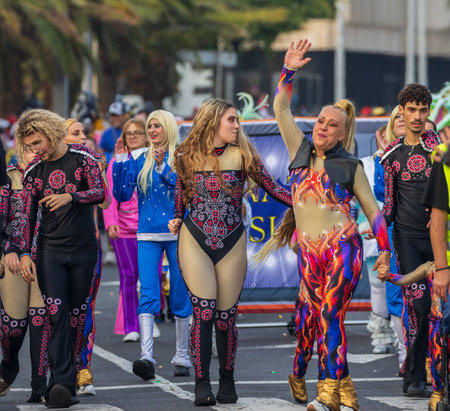 SANTA CRUZ DE TENERIFE, SPAIN - FEBRUARY 13, 2024: The Coso parade, Cavalcada - along the Avenida de Anaga, official end of Carnival. Amazing warm evening, joyful people in carnival costumes have fun.のeditorial素材