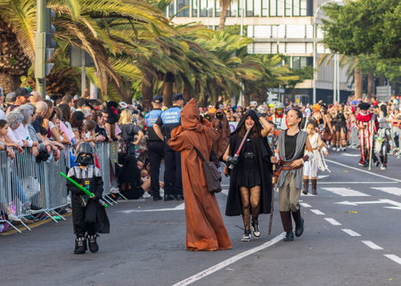 SANTA CRUZ DE TENERIFE, SPAIN - FEBRUARY 13, 2024: The Coso parade, Cavalcada - along the Avenida de Anaga, official end of Carnival. Amazing warm evening, joyful people in carnival costumes have fun.のeditorial素材