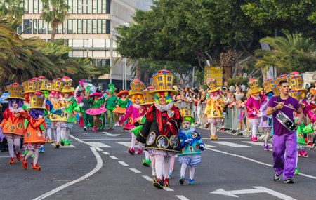 SANTA CRUZ DE TENERIFE, SPAIN - FEBRUARY 13, 2024: The Coso parade, Cavalcada - along the Avenida de Anaga, official end of Carnival. Amazing warm evening, joyful people in carnival costumes have fun.のeditorial素材