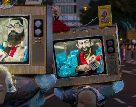 SANTA CRUZ DE TENERIFE, SPAIN - FEBRUARY 13, 2024: The Coso parade, Cavalcada - along the Avenida de Anaga, official end of Carnival. Amazing warm evening, joyful people in carnival costumes have fun.のeditorial素材