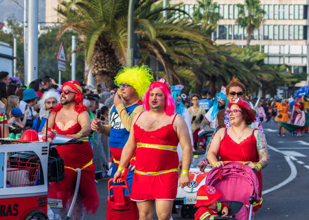 SANTA CRUZ DE TENERIFE, SPAIN - FEBRUARY 13, 2024: The Coso parade, Cavalcada - along the Avenida de Anaga, official end of Carnival. Amazing warm evening, joyful people in carnival costumes have fun.のeditorial素材