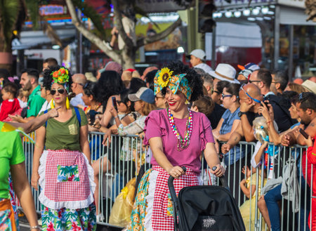 SANTA CRUZ DE TENERIFE, SPAIN - FEBRUARY 13, 2024: The Coso parade, Cavalcada - along the Avenida de Anaga, official end of Carnival. Amazing warm evening, joyful people in carnival costumes have fun.のeditorial素材