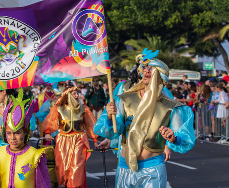 SANTA CRUZ DE TENERIFE, SPAIN - FEBRUARY 13, 2024: The Coso parade, Cavalcada - along the Avenida de Anaga, official end of Carnival. Amazing warm evening, joyful people in carnival costumes have fun.のeditorial素材