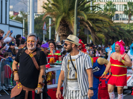 SANTA CRUZ DE TENERIFE, SPAIN - FEBRUARY 13, 2024: The Coso parade, Cavalcada - along the Avenida de Anaga, official end of Carnival. Amazing warm evening, joyful people in carnival costumes have fun.のeditorial素材