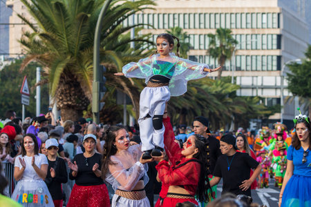 SANTA CRUZ DE TENERIFE, SPAIN - FEBRUARY 13, 2024: The Coso parade, Cavalcada - along the Avenida de Anaga, official end of Carnival. Amazing warm evening, joyful people in carnival costumes have fun.のeditorial素材
