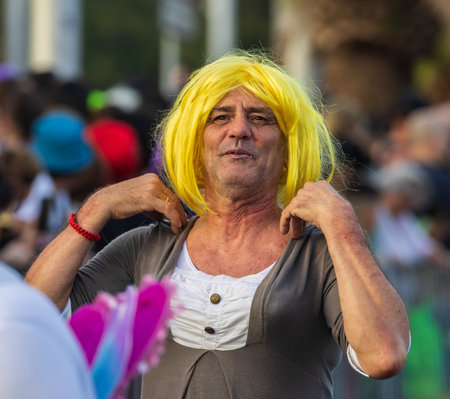 SANTA CRUZ DE TENERIFE, SPAIN - FEBRUARY 13, 2024: The Coso parade, Cavalcada - along the Avenida de Anaga, official end of Carnival. Amazing warm evening, joyful people in carnival costumes have fun.のeditorial素材