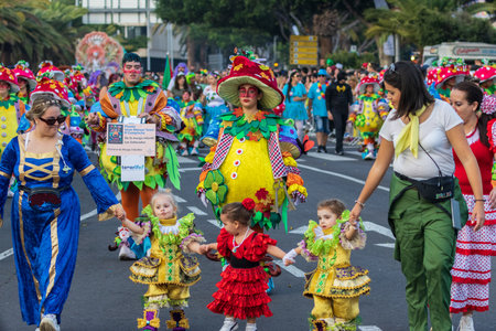 SANTA CRUZ DE TENERIFE, SPAIN - FEBRUARY 13, 2024: The Coso parade, Cavalcada - along the Avenida de Anaga, official end of Carnival. Amazing warm evening, joyful people in carnival costumes have fun.のeditorial素材