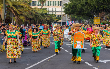 SANTA CRUZ DE TENERIFE, SPAIN - FEBRUARY 13, 2024: The Coso parade, Cavalcada - along the Avenida de Anaga, official end of Carnival. Amazing warm evening, joyful people in carnival costumes have fun.のeditorial素材