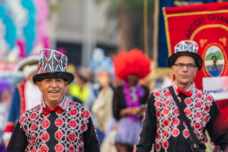 SANTA CRUZ DE TENERIFE, SPAIN - FEBRUARY 13, 2024: The Coso parade, Cavalcada - along the Avenida de Anaga, official end of Carnival. Amazing warm evening, joyful people in carnival costumes have fun.のeditorial素材