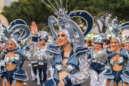 SANTA CRUZ DE TENERIFE, SPAIN - FEBRUARY 13, 2024: The Coso parade, Cavalcada - along the Avenida de Anaga, official end of Carnival. Amazing warm evening, joyful people in carnival costumes have fun.のeditorial素材
