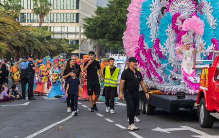 SANTA CRUZ DE TENERIFE, SPAIN - FEBRUARY 13, 2024: The Coso parade, Cavalcada - along the Avenida de Anaga, official end of Carnival. Amazing warm evening, joyful people in carnival costumes have fun.のeditorial素材