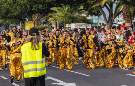 SANTA CRUZ DE TENERIFE, SPAIN - FEBRUARY 13, 2024: The Coso parade, Cavalcada - along the Avenida de Anaga, official end of Carnival. Amazing warm evening, joyful people in carnival costumes have fun.のeditorial素材