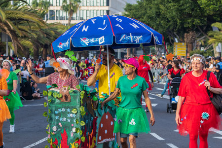 SANTA CRUZ DE TENERIFE, SPAIN - FEBRUARY 13, 2024: The Coso parade, Cavalcada - along the Avenida de Anaga, official end of Carnival. Amazing warm evening, joyful people in carnival costumes have fun.のeditorial素材