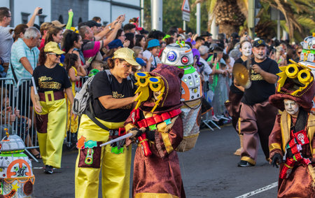 SANTA CRUZ DE TENERIFE, SPAIN - FEBRUARY 13, 2024: The Coso parade, Cavalcada - along the Avenida de Anaga, official end of Carnival. Amazing warm evening, joyful people in carnival costumes have fun.のeditorial素材