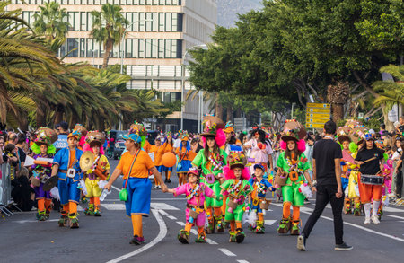 SANTA CRUZ DE TENERIFE, SPAIN - FEBRUARY 13, 2024: The Coso parade, Cavalcada - along the Avenida de Anaga, official end of Carnival. Amazing warm evening, joyful people in carnival costumes have fun.のeditorial素材