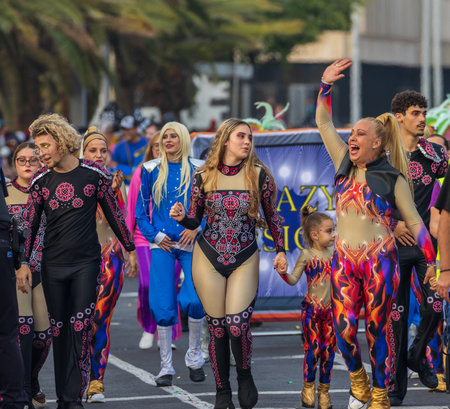 SANTA CRUZ DE TENERIFE, SPAIN - FEBRUARY 13, 2024: The Coso parade, Cavalcada - along the Avenida de Anaga, official end of Carnival. Amazing warm evening, joyful people in carnival costumes have fun.のeditorial素材
