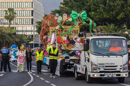 SANTA CRUZ DE TENERIFE, SPAIN - FEBRUARY 13, 2024: The Coso parade, Cavalcada - along the Avenida de Anaga, official end of Carnival. Amazing warm evening, joyful people in carnival costumes have fun.のeditorial素材