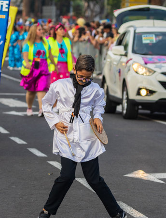 SANTA CRUZ DE TENERIFE, SPAIN - FEBRUARY 13, 2024: The Coso parade, Cavalcada - along the Avenida de Anaga, official end of Carnival. Amazing warm evening, joyful people in carnival costumes have fun.のeditorial素材