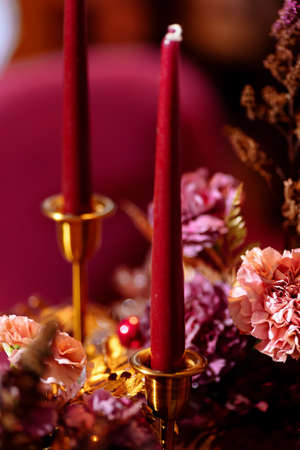 Red candles in gold candlesticks on a blurred background. Selected focusの写真素材