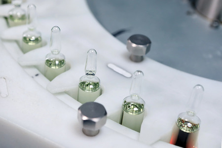 Sterile bottles and ampoules on the dispensing line. Sealed ampoules with medicine.の写真素材