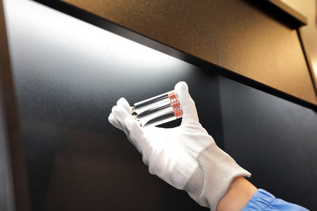 Quality Control vials for injection. Individual checks vial under a microscope. New pharmaceutical. Production of sterile medications. Pharmacology and people together. The ampoule under a microscope.の写真素材