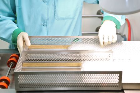 Visual control of ampoules with medicine. A woman works on an ampoule production line. Sterile...