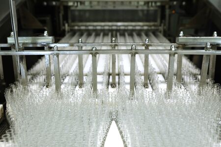 Visual control of ampoules with medicine. A woman works on an ampoule production line. Sterile...