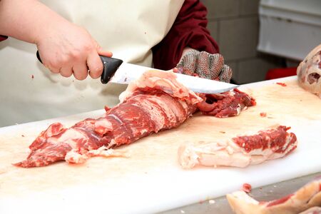Prepares sausages at the work table. Food processing and processing industry. Raw meat mix: steaks, poultry, sausages, ham, chopped, minced meat. The farm. Unique home production.の写真素材