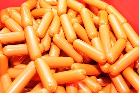 A worker at the meat processing factory, prepares sausages at the work table. Food processing and processing industry. Raw meat mix: steaks, poultry, sausages, ham, chopped, minced meat. The farm. Unique home production.の写真素材