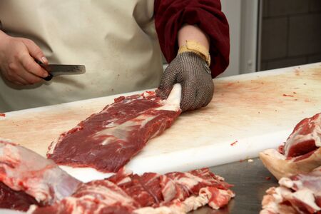 Prepares sausages at the work table. Food processing and processing industry. Raw meat mix: steaks,...